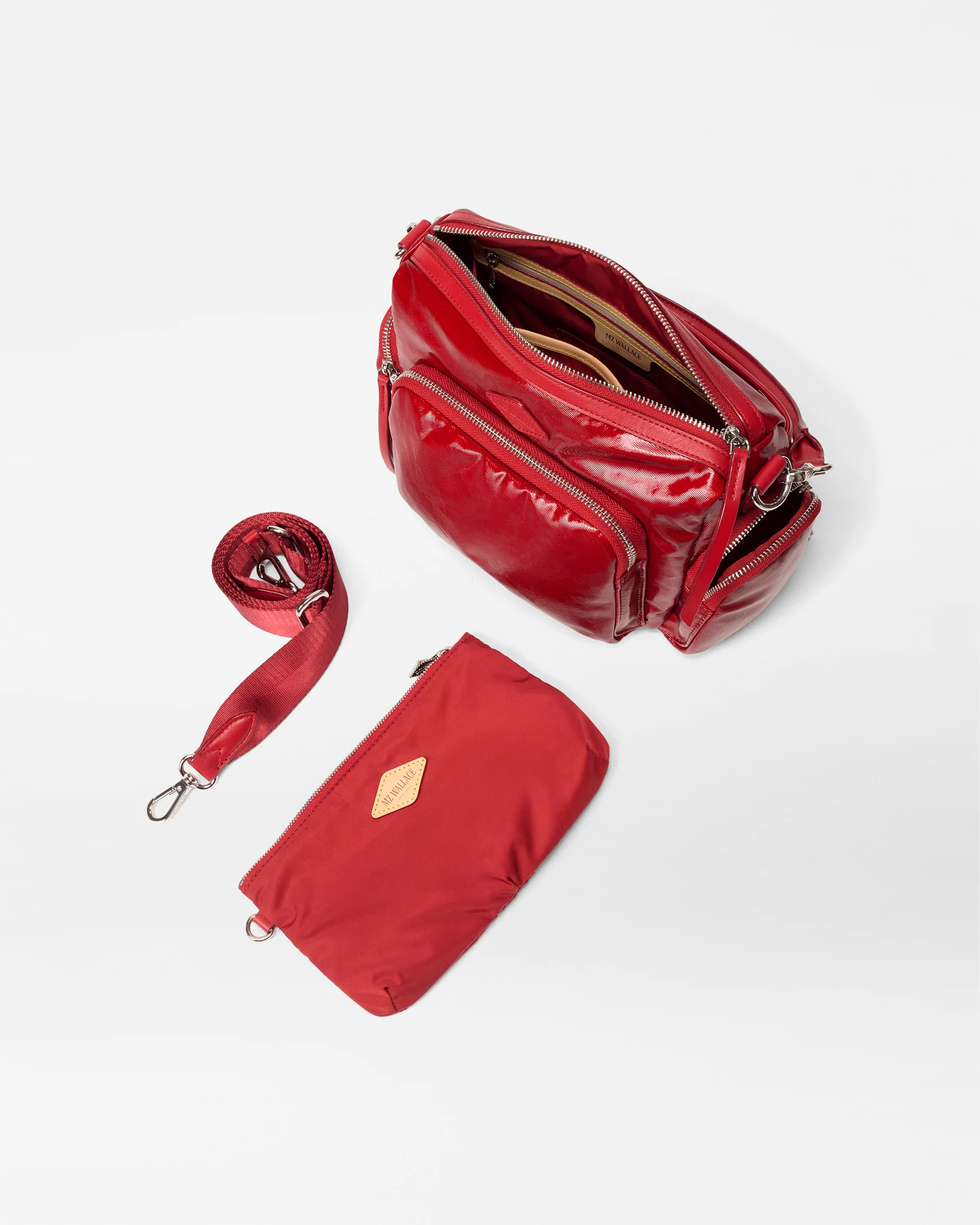 Red handbag with a matching pouch and strap on a white background